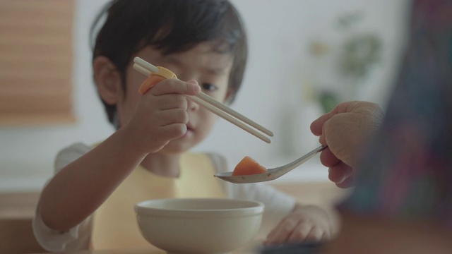 奶奶和孙女在餐桌上吃面条视频素材