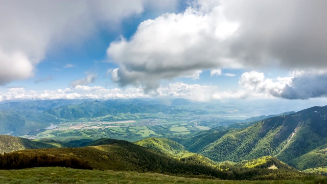 在阳光明媚的夏天，云在绿色的高山景观上移动视频素材