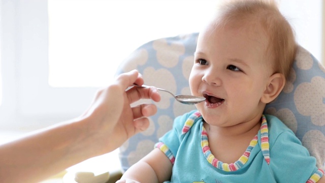 母亲用勺子喂婴儿食物视频素材