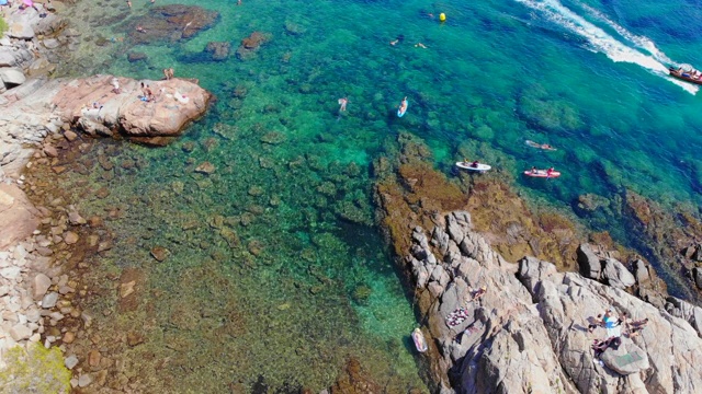 鸟瞰图的科斯塔布拉瓦天堂海滩在夏天和人们在清澈的水域游泳。视频素材