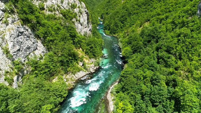 飞过绿树环绕的峡谷和绿水环绕的山河。无人机拍摄，4K视频素材