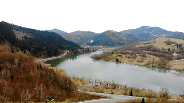 在多云天气下从山上的湖上取下无人机。美丽的秋天风景与森林和山脉。视频素材