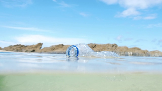 海上漂浮着用过的塑料水瓶。视频下载