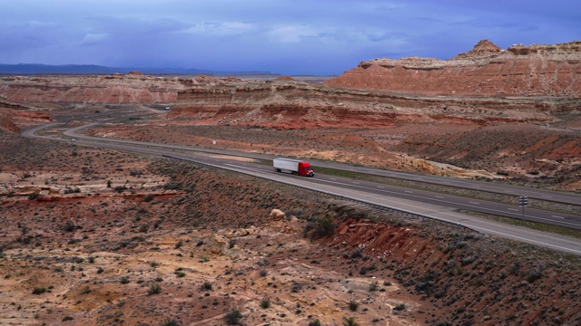 珊瑚峡谷US-70高速公路上的卡车。美国犹他州的圣拉斐尔斯韦尔观点，在早春的景色。跟踪卡车的平移摄像机运动。视频素材