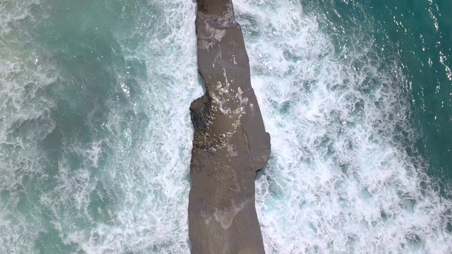 航拍的海岸岩石和冲击海浪视频素材