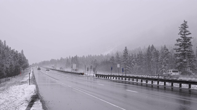 在科罗拉多州山区的高速公路上，在大雪中危险驾驶，平移摄像机运动跟踪汽车。视频素材