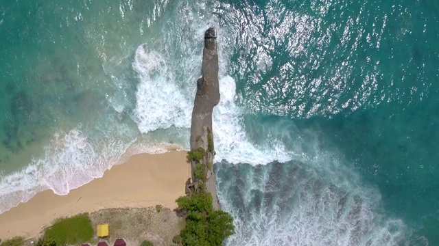 顶视图的海岸岩石和碰撞海洋颜色的波浪视频素材