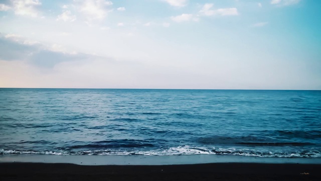 热带海滩地平线上的海浪和海滩云和行走在Umeanyar海滩上的人们视频素材