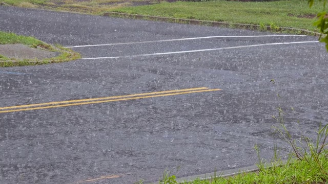 雨水滴落在沥青上的水坑里，由于雨季的大雨淹没了道路。视频素材