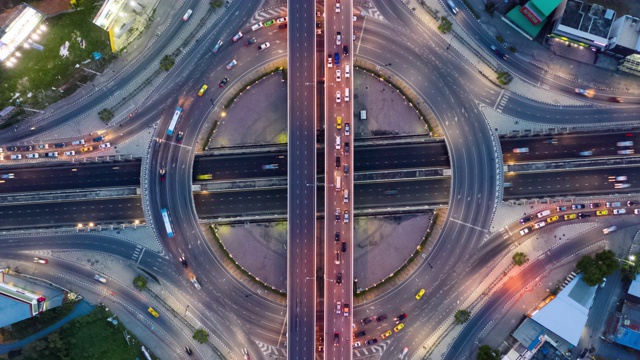 白天到夜晚的时间推移:环形道路交通的俯视图视频下载