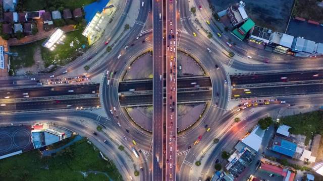 白天到夜晚的时间推移:环形道路交通的俯视图视频素材