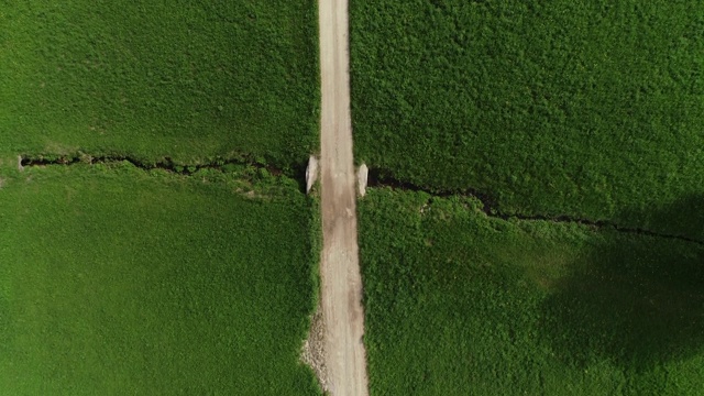 从高角度看，沿着乡村公路在草地上视频素材