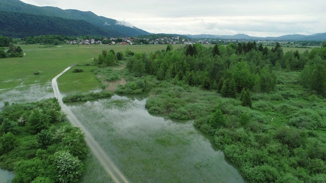 被水淹没的草地和村庄旁边的乡村道路视频素材