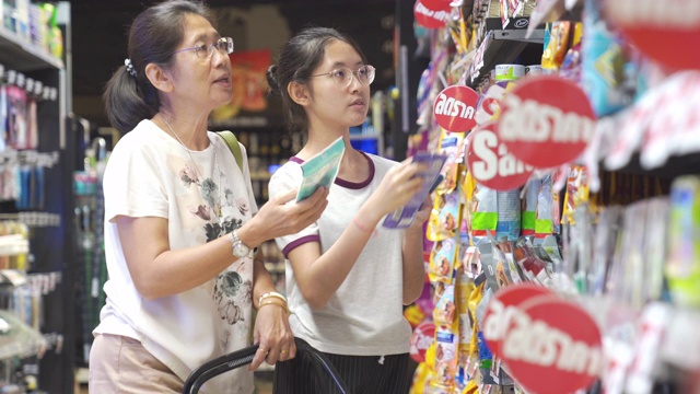 亚洲家庭母亲和十几岁的女孩喜欢在销售商店购物中心度假购物视频素材