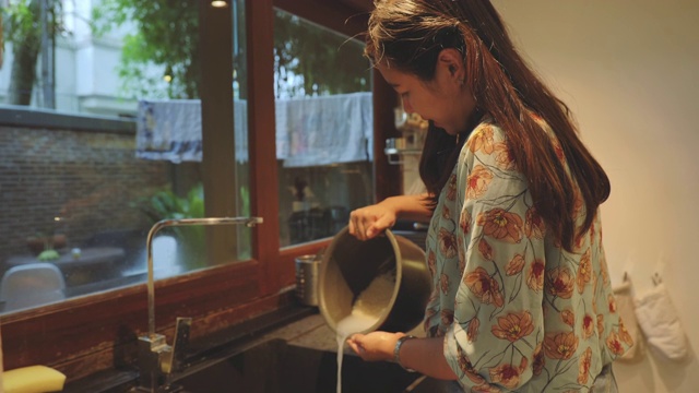 亚洲妇女在厨房煮饭的场景。视频素材