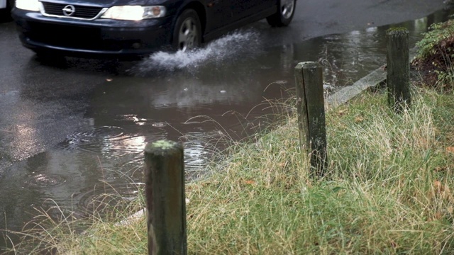 慢镜头里，汽车从雨坑里溅起水花视频素材