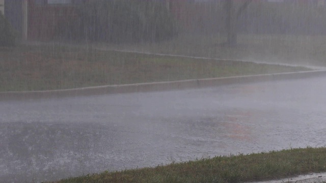 夏天的雷雨使居民区的道路溅得水花四溅视频素材