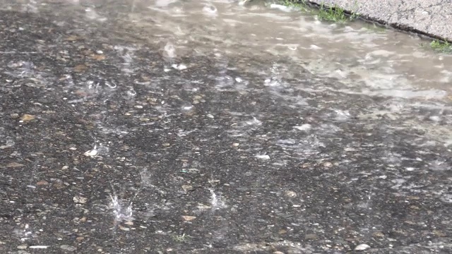 暴雨。大雨滴溅在柏油路上视频素材