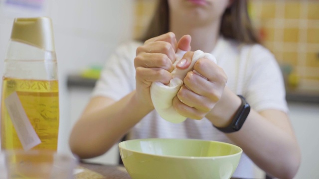 学校女孩的手玩自制的白色黏液的特写视频素材