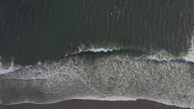 鸟瞰图的海滩与人们冲浪在印尼巴厘岛视频素材