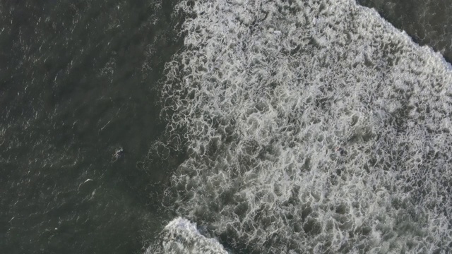 鸟瞰图的海滩与人们冲浪在印尼巴厘岛视频素材