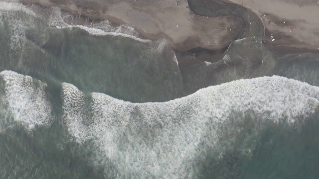 鸟瞰图的海滩与人们冲浪在印尼巴厘岛视频素材