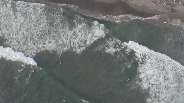 鸟瞰图的海滩与人们冲浪在印尼巴厘岛视频素材