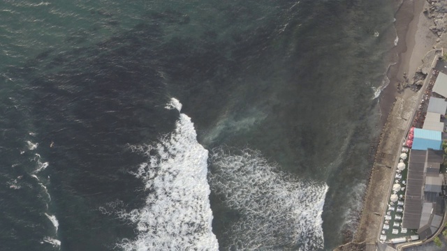 鸟瞰图的海滩与人们冲浪在印尼巴厘岛视频素材