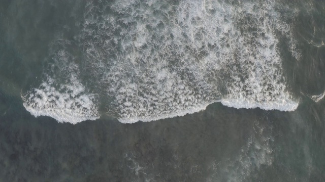 鸟瞰图的海滩与人们冲浪在印尼巴厘岛视频素材