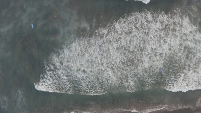 鸟瞰图的海滩与人们冲浪在印尼巴厘岛视频素材