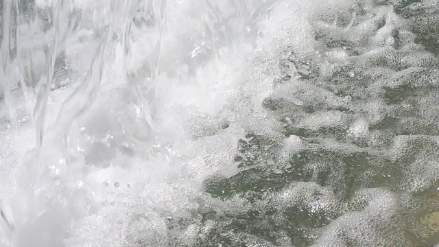 在一个阳光明媚的夏日，落下的水溅起许多水花，形成波浪视频下载