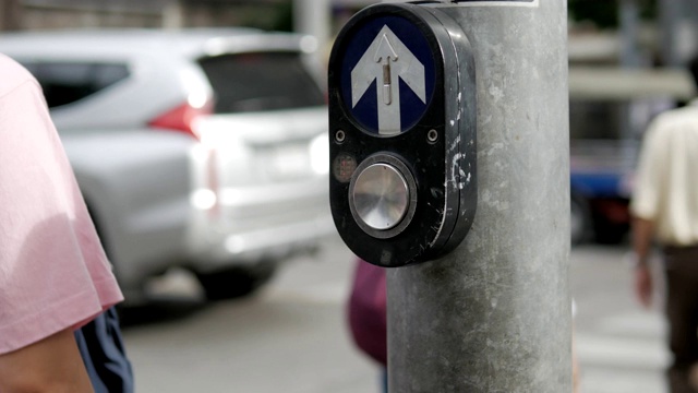 行人过街灯按钮与行人和汽车上的道路视频素材