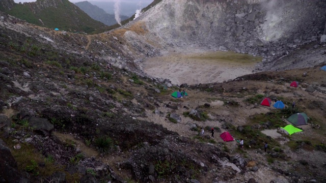 高角度倾斜:美丽的自然火山口景观，锡巴亚克火山山顶有许多帐篷视频素材