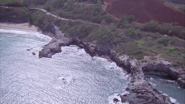 空中俯瞰在沿海高速公路上行驶的汽车，旁边是悬崖峭壁的海岸线。海滩。海洋。视频素材