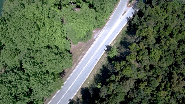 鸟瞰希腊北部树木之间的山区乡村道路，由无人机向下移动视频素材