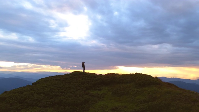 这对夫妇站在山顶上，背景是夕阳视频素材