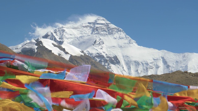 近距离观察:狂风将山顶上的积雪卷走，祈祷旗在风中飘扬视频素材