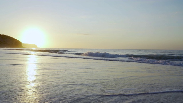 日出时海浪拍打着海滩视频素材