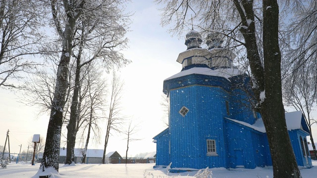 Staraya Belitsa， (Uritskiy Sel'sovet)，戈麦尔地区，白俄罗斯。在阳光明媚的冬日雪天，圣尼古拉斯神奇工人的老木制东正教教堂。降雪下的著名地标视频素材