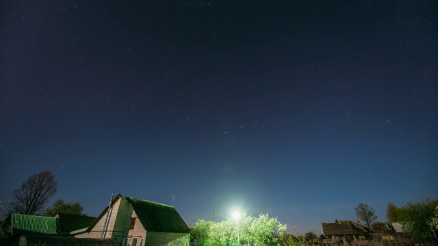 夜晚，村庄房屋上的星空背景。自然发光的星星夜景视频素材