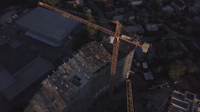 建筑起重机及在建建筑鸟瞰图。晚上争抢工地。视频下载