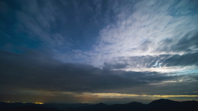 雨云在夜山上空流动。时间流逝视频素材