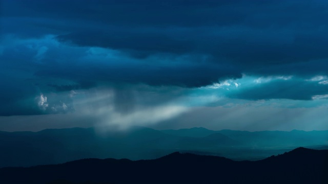 美丽的雨云在夜山之上流淌。时间流逝视频素材