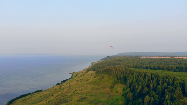 海岸线和沿着海岸线滑行的帆。跳伞运动员在空中飞行。视频素材