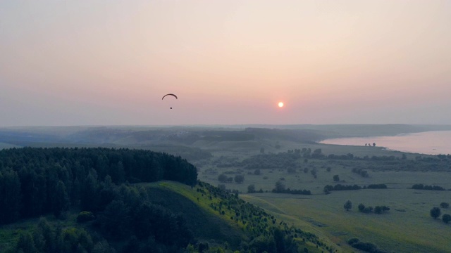 当太阳落山时，冲压式降落伞在天空中漂浮视频素材