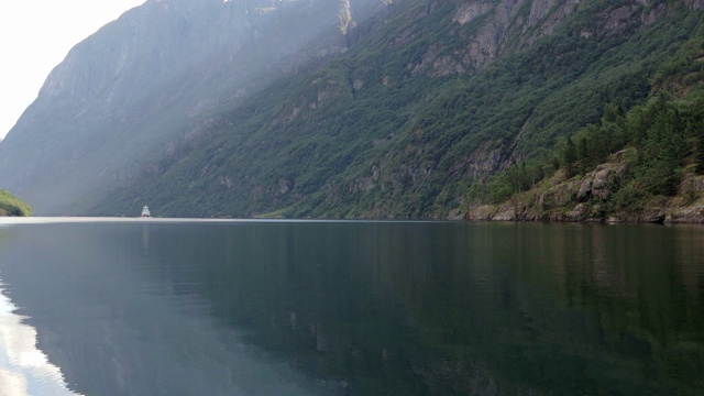 一艘大型旅游船在挪威古德万根峡湾的蓝色海水中航行。视频素材