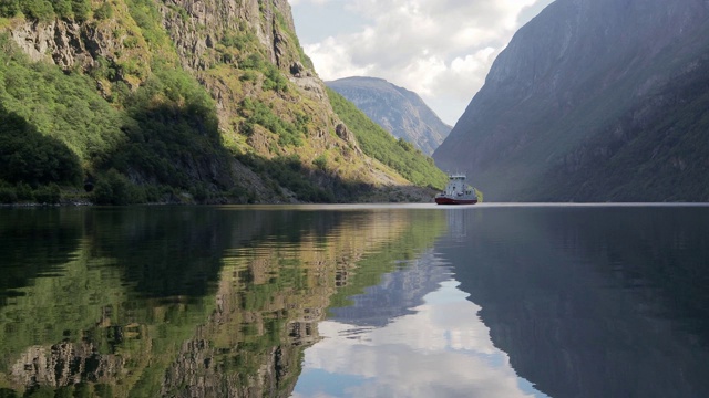 一艘大型旅游船在挪威古德万根峡湾的蓝色海水中航行。视频素材