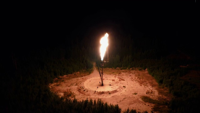 夜晚，森林的中央熊熊燃烧着一个巨大的火炬。气体处理，环境污染理念，全球变暖视频素材