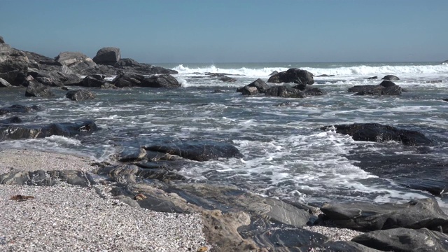 海浪拍打着岸边的石头。视频素材