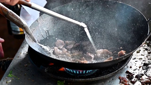 在泰国街头小吃用煎锅煮肉片视频素材